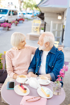 No age. Top view of nice senior couple sitting at cafe and gazing at each other