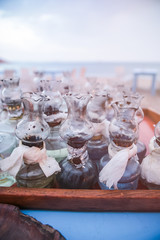 Old Oil Glass Lamps with DIY fixes gathered on Table on Greek Beach at Sunset.