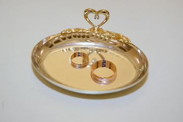 Wedding gold rings on a platter. Ring of the bride and groom for the ceremony.