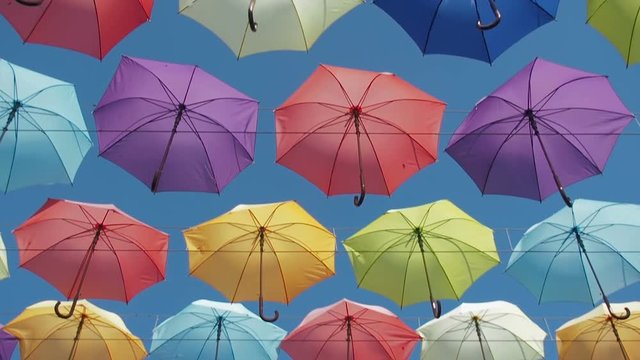The sky is in umbrellas. Colored umbrellas against the sky.