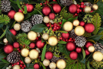 Christmas background with red and gold bauble decorations with flora of holly, ivy, mistletoe and pine cones. Traditional Christmas greeting card for the holiday season.