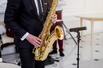 Fototapeta premium Gold saxophone with specks on it in male hands