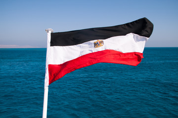 Egyptian Flag Floating in the Sun with Red Sea in the Background.