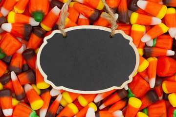 Halloween candy corn background with hanging retro chalkboard for your message