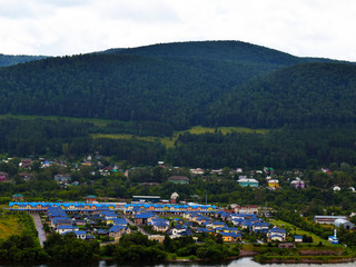 Fototapeta na wymiar A small village located at the foot of the mountain. Beautiful mountain view. Siberian nature. Attractions Of Krasnoyarsk Region.
