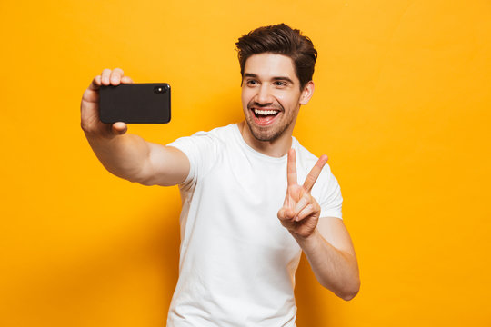 Portrait of a cheerful young man taking a sefie
