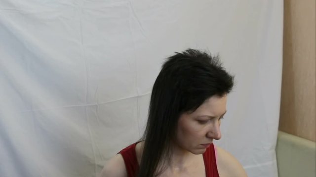 the girl cuts her long dark hair very short. Average shot, inside, real time, one person, contains people