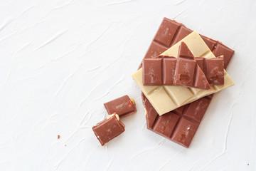 White and milk chocolate. Tiles of chocolate on a white background