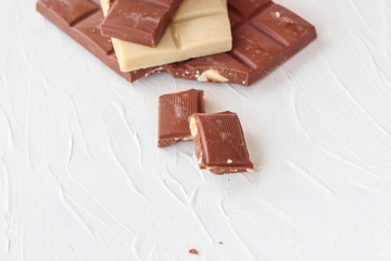 White and milk chocolate. Tiles of chocolate on a white background