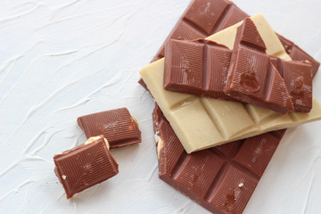 White and milk chocolate. Tiles of chocolate on a white background