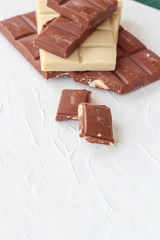 White and milk chocolate. Tiles of chocolate on a white background
