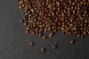 Coffee grains on a dark background. A delicious fragrant coffee of the best varieties. Coffee texture. Coffee beans background