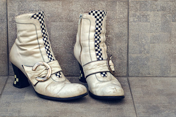 Old boots with buckles on a dirty concrete background