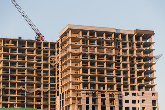 Tall Building Under Construction Under Cloudy Sunset.