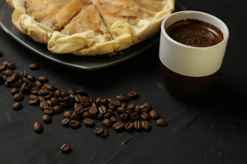 Apple cake with almond cream on a dark background. Baked cake with coffee nd coffee beans. Pie for the whole family on a sunny day