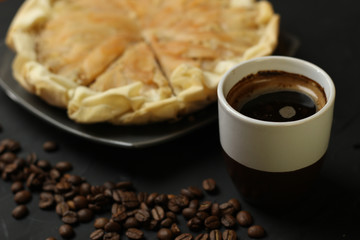 Apple cake with almond cream on a dark background. Baked cake with coffee nd coffee beans. Pie for the whole family on a sunny day