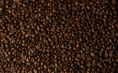 Coffee grains on a dark background. A delicious fragrant coffee of the best varieties. Coffee texture. Coffee beans background