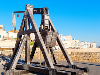 Ancient catapult on the walls of the city of Alghero. In the background a view of the city