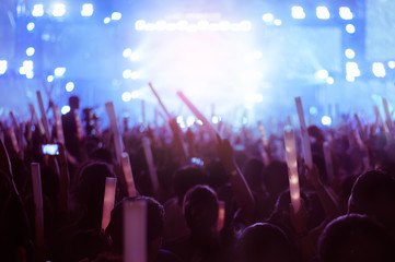 silhouettes of hand in concert.Light from the stage.