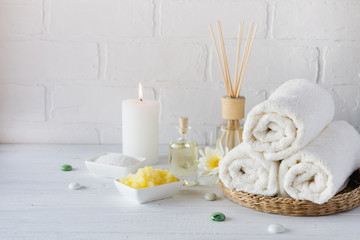 Obraz na płótnie Canvas Spa still life with towel,white lily, sea salt, bath oil, sugar body scrub and candle