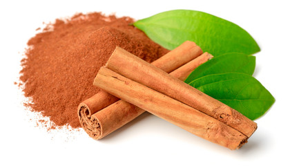 cinnamon powder and sticks with fresh leaves isolated on white