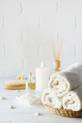 SPA aromatherapy background.  Still life with white towel, bath oil, massage brush and candle.