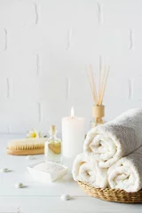 Fototapeten SPA aromatherapy background.  Still life with white towel, bath oil, massage brush and candle. © Iryna