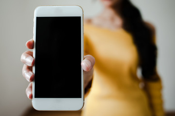 image of hand holding white mobile phone with blank black screen