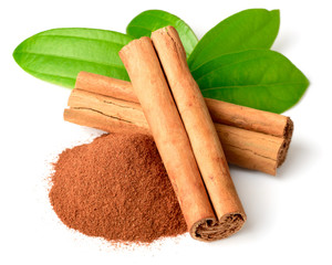 cinnamon powder and sticks with fresh leaves isolated on white