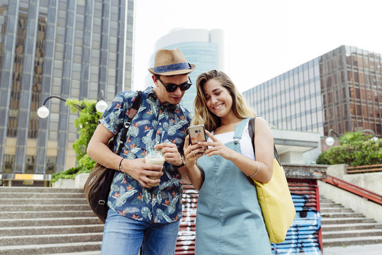 Couple browsing smartphone on street