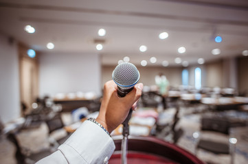 Hand holding microphone in conference hall