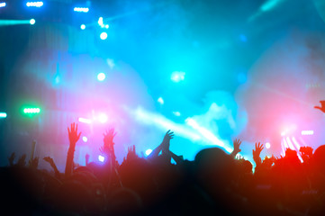 silhouettes of hand in concert.Light from the stage.