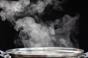 Traditional silver cooking pot with white smoke