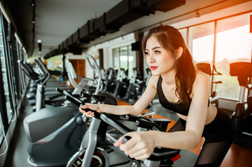 Fototapeta na wymiar Fitness woman working out on exercise bike at the gym.exercising concept.fitness and healthy lifestyle
