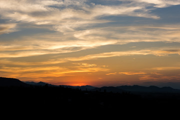 Cloudscape after sunset above the silhouette hills