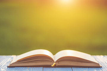 Book on wooden table with abstract blur and bokeh in sunrise or sunset time