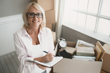 Smiling Blond Woman with Glasses with Notebook.
