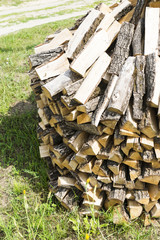 Wooden firewood stuked on a green grass