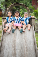 three children sitting on the top of slider
