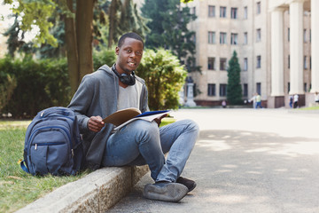 Fototapeta premium African-american student sitting with notebook in university campus