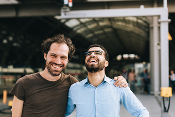 Deutscher Mann und syrischer Mann lachen gemeinsam