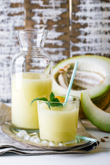 smoothies melon in a glass and a bottle on a wooden background, summer drink, cocktail