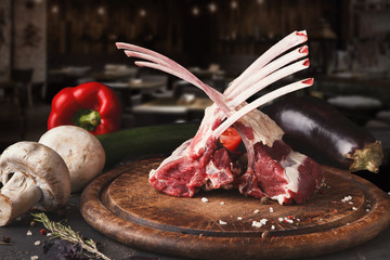 Raw rack of lamb on wooden board