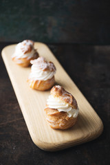 Choux pastry or choux cream or eclair dish on rustic background