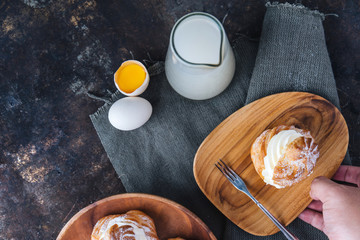 Choux pastry or choux cream or eclair dish on rustic background
