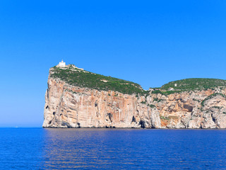 Fototapeta na wymiar A beautiful view of the cliffs with the lighthouse Capo Caccia (Alghero). Sardinia, Italy