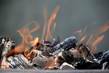 Wood burning with orange flames, grey smoke