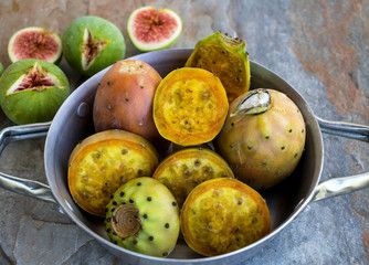 Eine Schüssel mit Kaktusfeigen und feigen auf einer Natursteinplatte