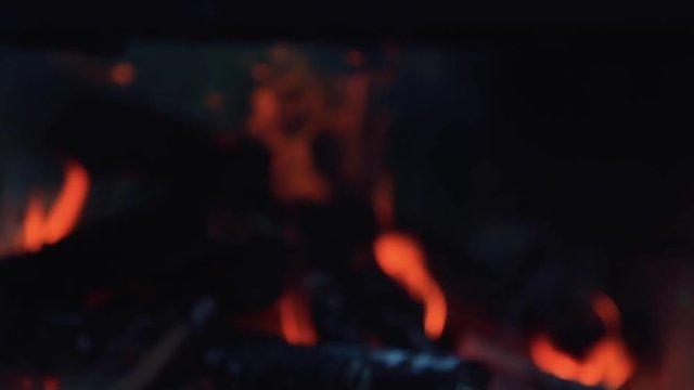 Fire in different autofocus with beautiful bokeh. Burning wood in bright flames in the dark, close up, dynamic scene, toned video, 50fps