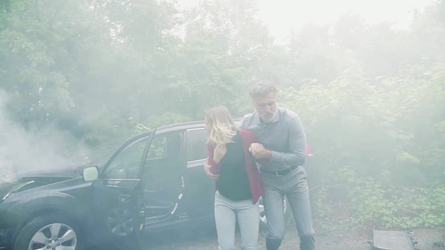 A mature man and a young woman running from the car after an accident.